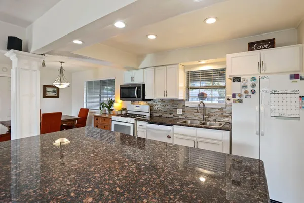 a kitchen with stainless steel appliances a stove a sink cabinets and a refrigerator