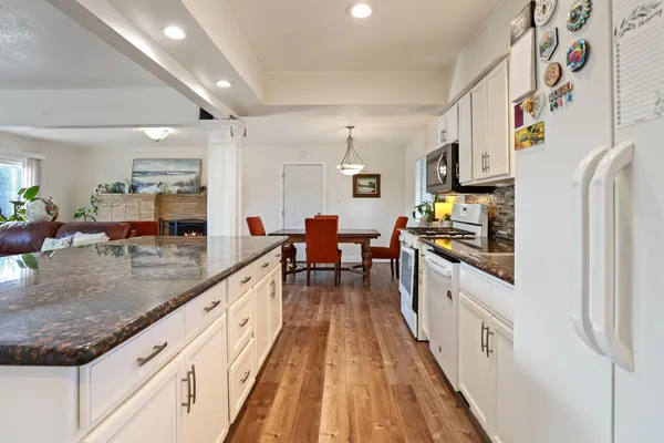 a kitchen with granite countertop lots of counter top space and wooden floor