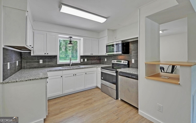 156 White Pine Road Toccoa, GA 30577 - Photo 3 of 57 a kitchen with granite countertop a stove top oven sink and cabinets