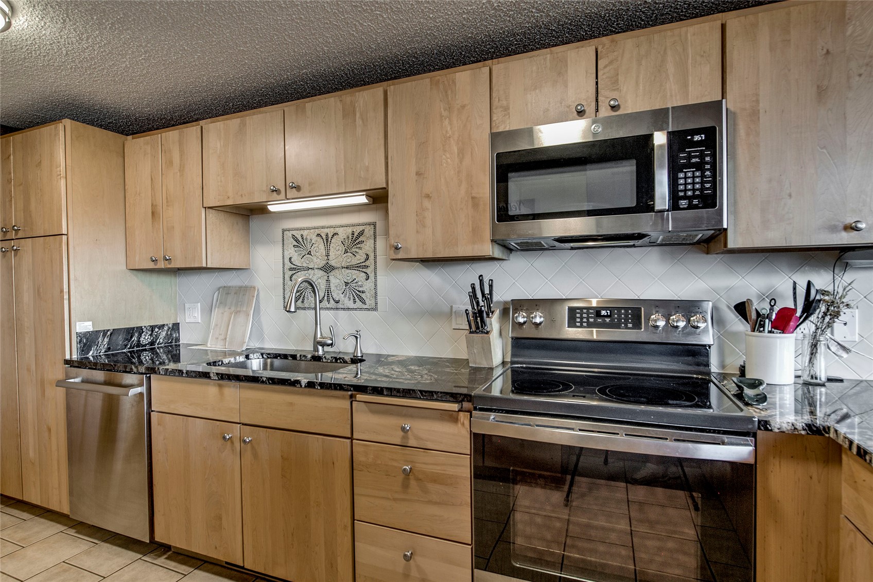 187 Fuller Placer Road, Unit B Breckenridge, CO 80424 - Photo 9 of 33 a kitchen with stainless steel appliances granite countertop a sink a stove a microwave and cabinets