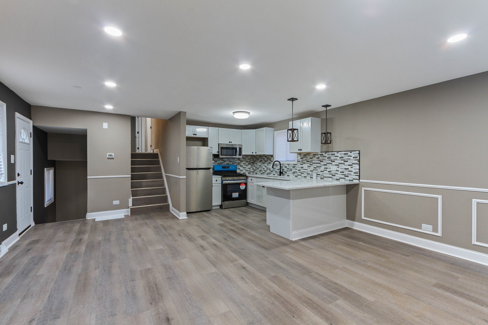 10002 South Normal Avenue Chicago, IL 60628 - Photo 12 of 29 a large white kitchen with stainless steel appliances kitchen island a large counter top and floors