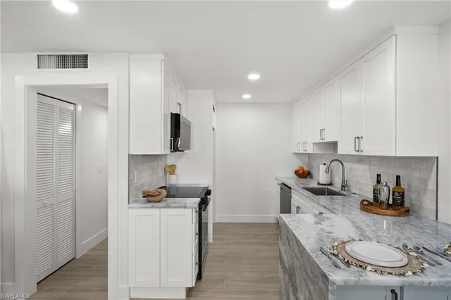 a kitchen with sink refrigerator and cabinets