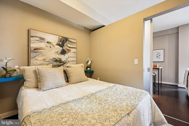 a bedroom with a bed and painting on the wall