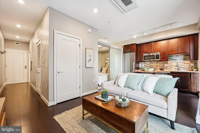 a living room with stainless steel appliances kitchen island granite countertop furniture and a view of kitchen