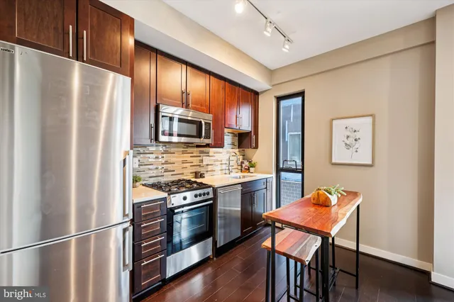 a kitchen with stainless steel appliances granite countertop a stove refrigerator and microwave