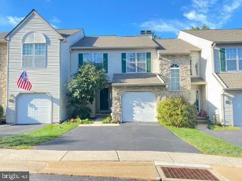 a front view of a house with a yard and a garage