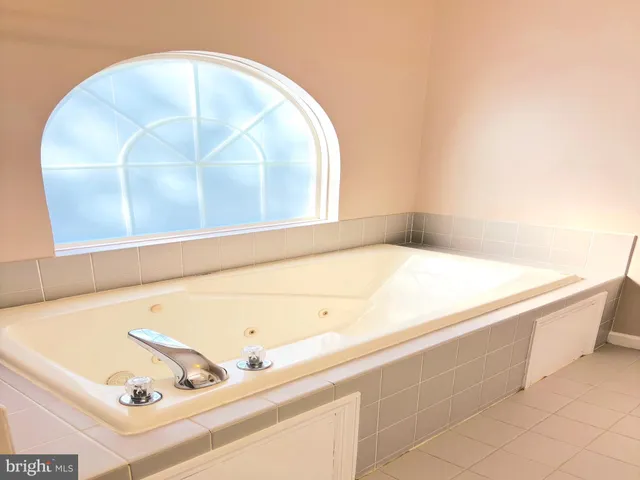 a spacious bathroom with a granite countertop sink and a mirror
