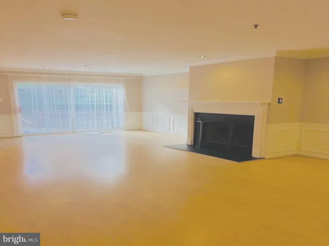 a view of an empty room with a fireplace and a window
