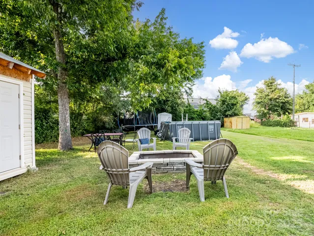 a view of a chair and table in backyard of the house