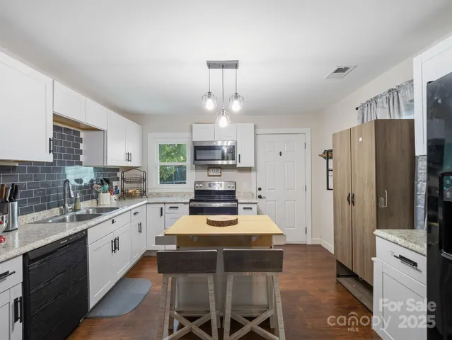 a kitchen with a refrigerator a stove a sink dishwasher and white cabinets with wooden floor