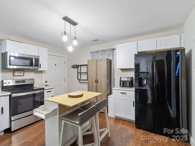 a kitchen with stainless steel appliances a stove refrigerator sink and microwave