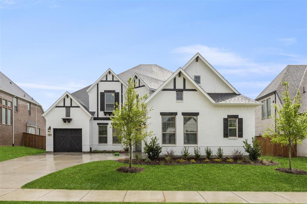 a front view of a house with a yard and trees