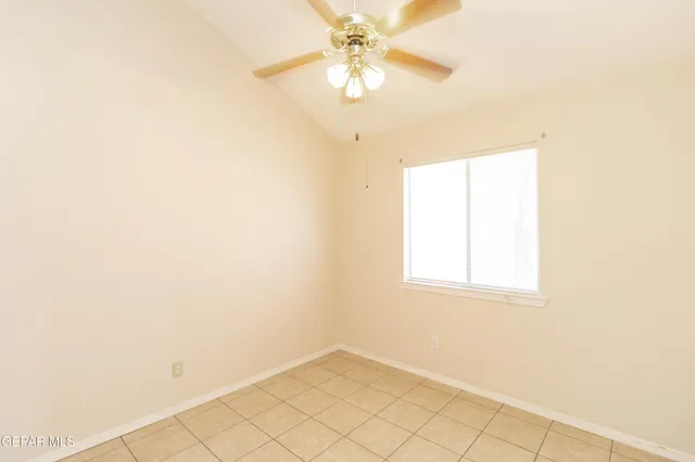 an empty room with a window and a chandelier fan