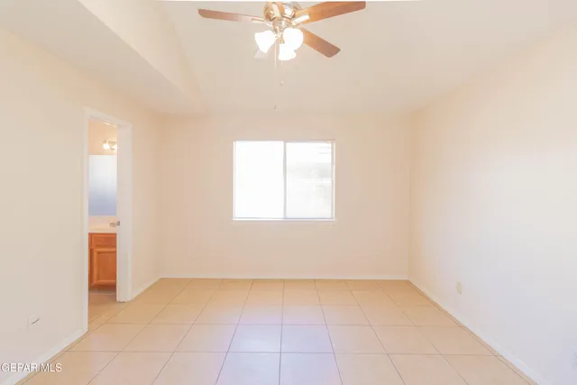 an empty room with a ceiling fan and window