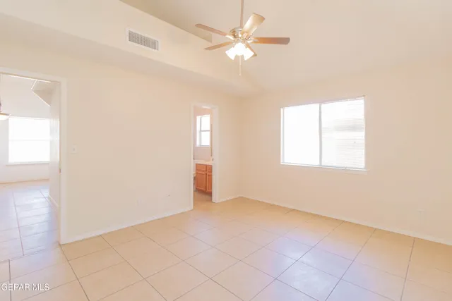an empty room with windows and fan