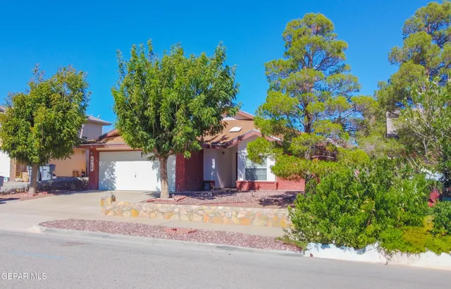 a front view of a house with a yard and fountain in middle