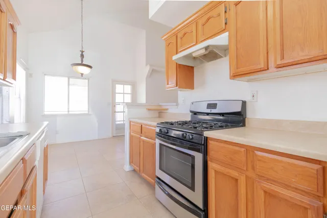 a kitchen with stainless steel appliances granite countertop a stove a sink and a microwave