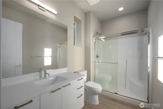 a bathroom with a granite countertop sink toilet and shower