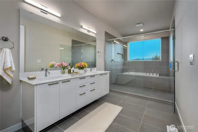 a bathroom with a sink mirror and a shower