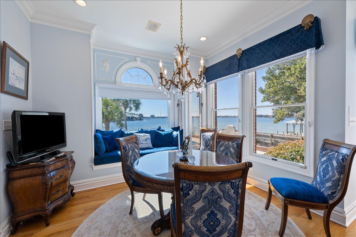 83 Poquito Road Shalimar, FL 32579 - Photo 27 of 83 a dining room with furniture a chandelier and a flat screen tv