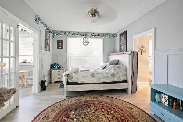 a bedroom with a bed and wooden floor