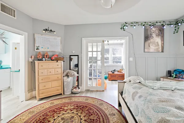 a bedroom with a bed and wooden floor