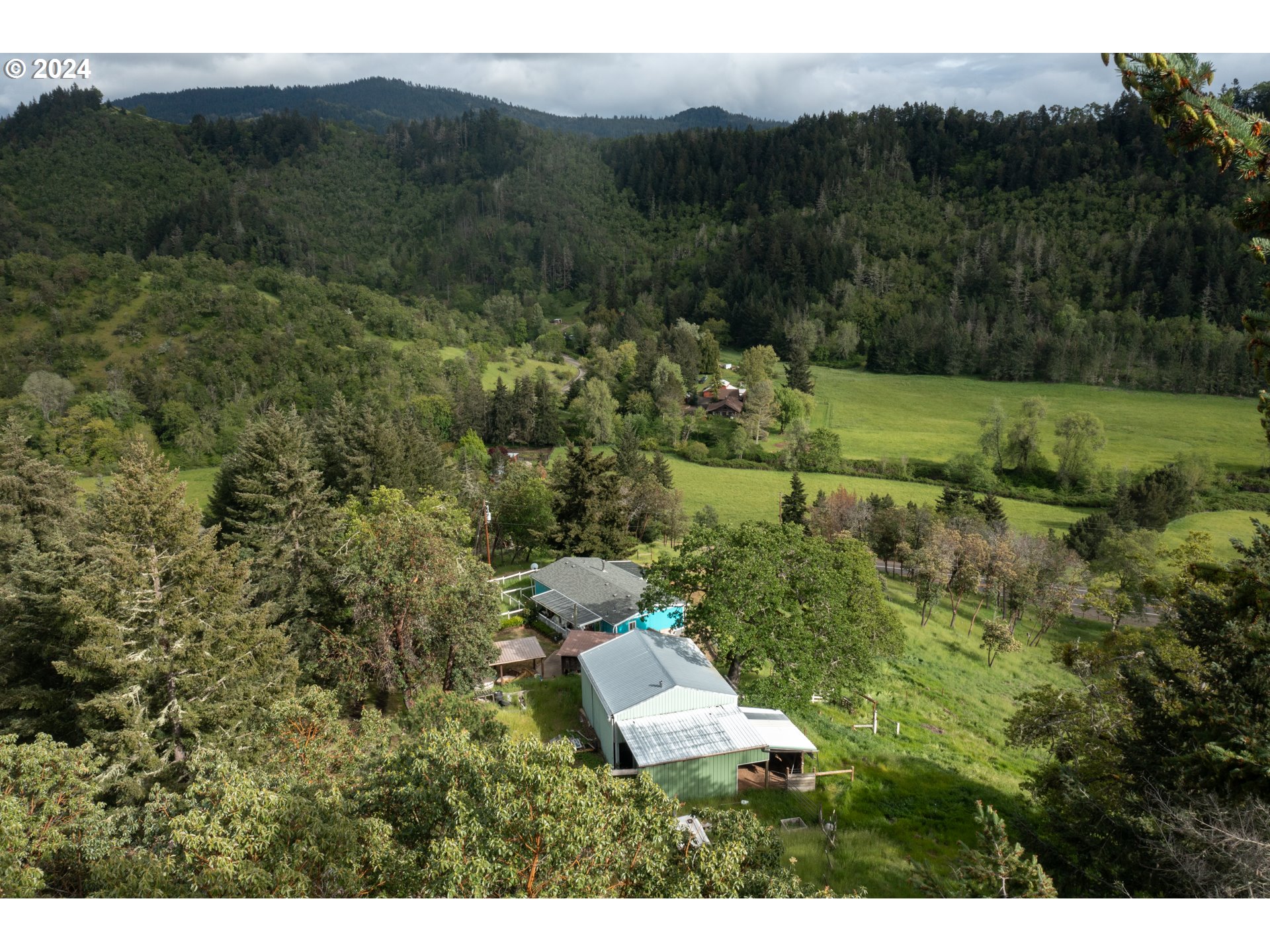 1120 Clarks Branch Road Myrtle Creek, OR 97457 - Photo 35 of 37 a view of a lush green forest with trees and some houses