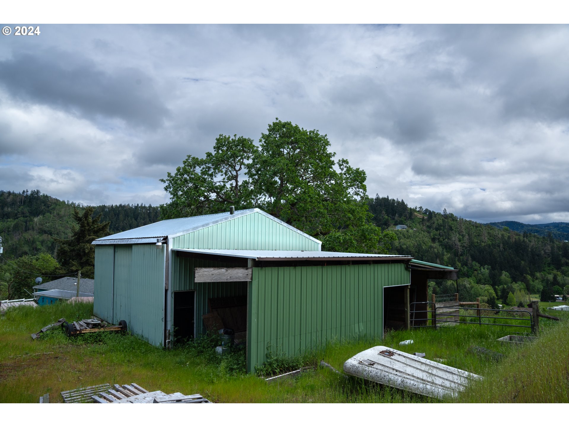 1120 Clarks Branch Road Myrtle Creek, OR 97457 - Photo 6 of 37 a backyard of a house with plants and barbeque oven
