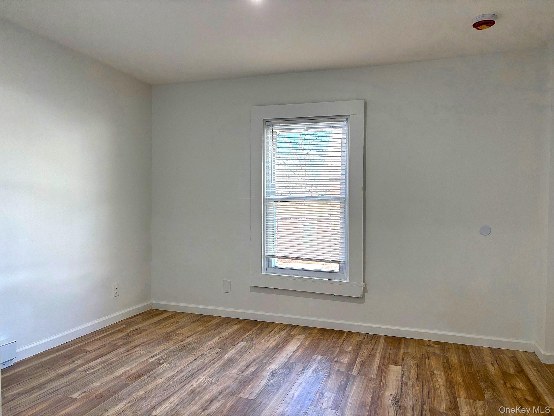 447 Highway 376, Unit 2 Hopewell Junction, NY 12533 - Photo 10 of 12 an empty room with wooden floor and windows