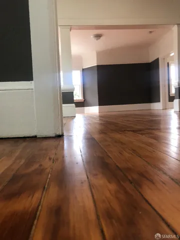 a view of a room with wooden floor and a window