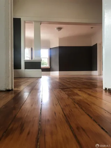 a view of a kitchen with stainless steel appliances wooden floor and a window