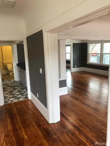 a view of empty room with wooden floor