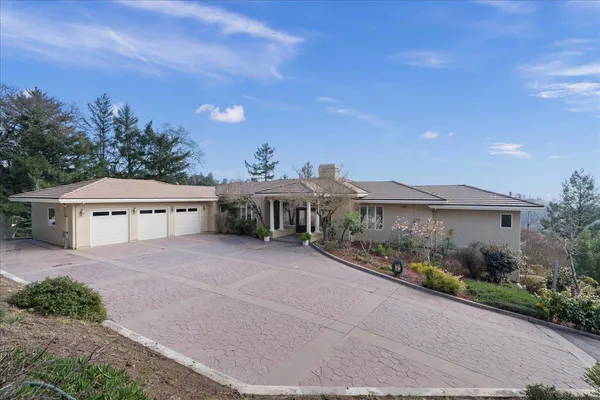 a view of a house with a yard and potted plants