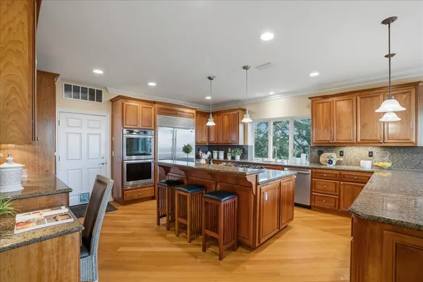 a kitchen with a stove a sink a counter space and living room view