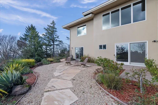 a view of a house with pool and trees in the background