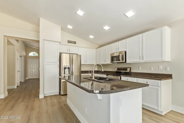 a kitchen with stainless steel appliances granite countertop a refrigerator stove microwave and sink