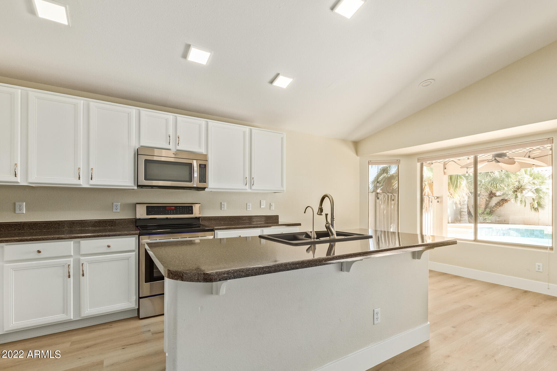 1647 East Heather Avenue Gilbert, AZ 85234 - Photo 11 of 27 a kitchen with granite countertop a sink a stove top oven a counter space and cabinets