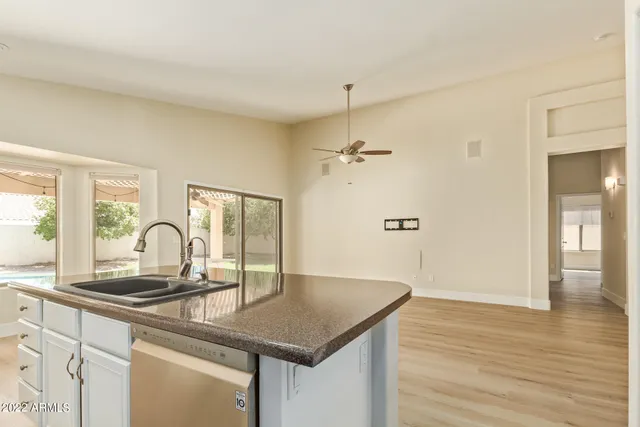 a kitchen with granite countertop a sink cabinets and wooden floor
