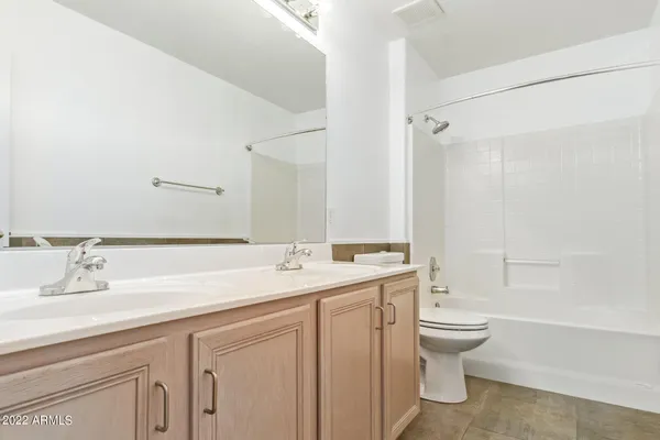 a bathroom with a granite countertop sink a toilet and a bathtub