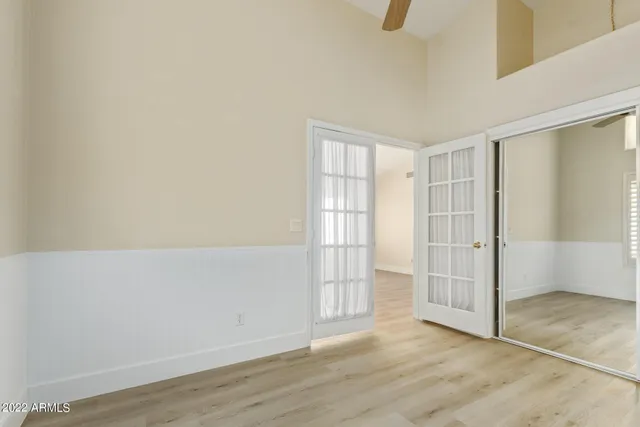 an empty room with wooden floor and windows