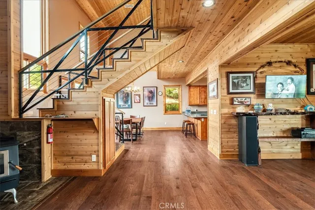 a kitchen with granite countertop wooden floors stainless steel appliances a sink and a window