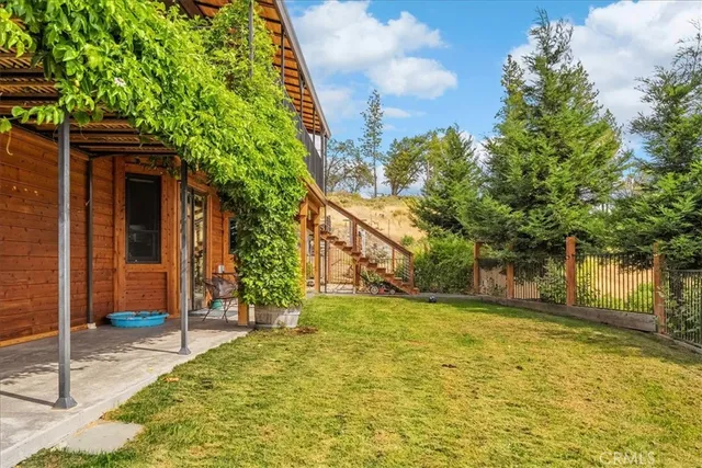 a view of a house with a yard and wooden fence