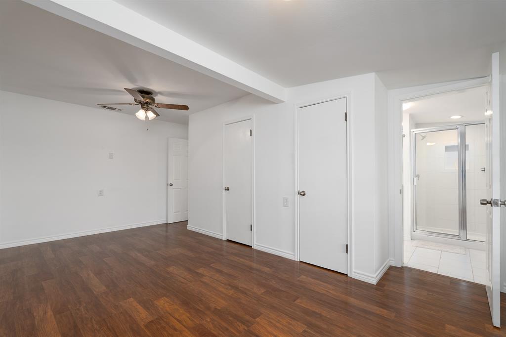 809 Turner Lane Tuscola, TX 79562 - Photo 13 of 25 Unfurnished bedroom with dark wood-type flooring, connected bathroom, and a ceiling fan
