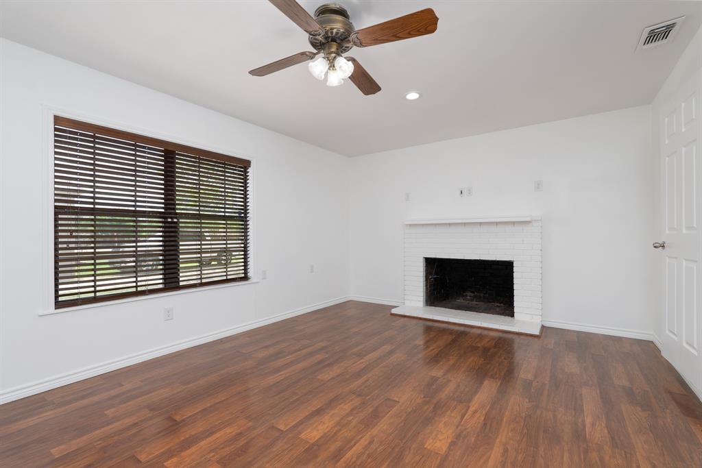 809 Turner Lane Tuscola, TX 79562 - Photo 2 of 25 Unfurnished living room with wood finished floors, a fireplace, a ceiling fan, and recessed lighting