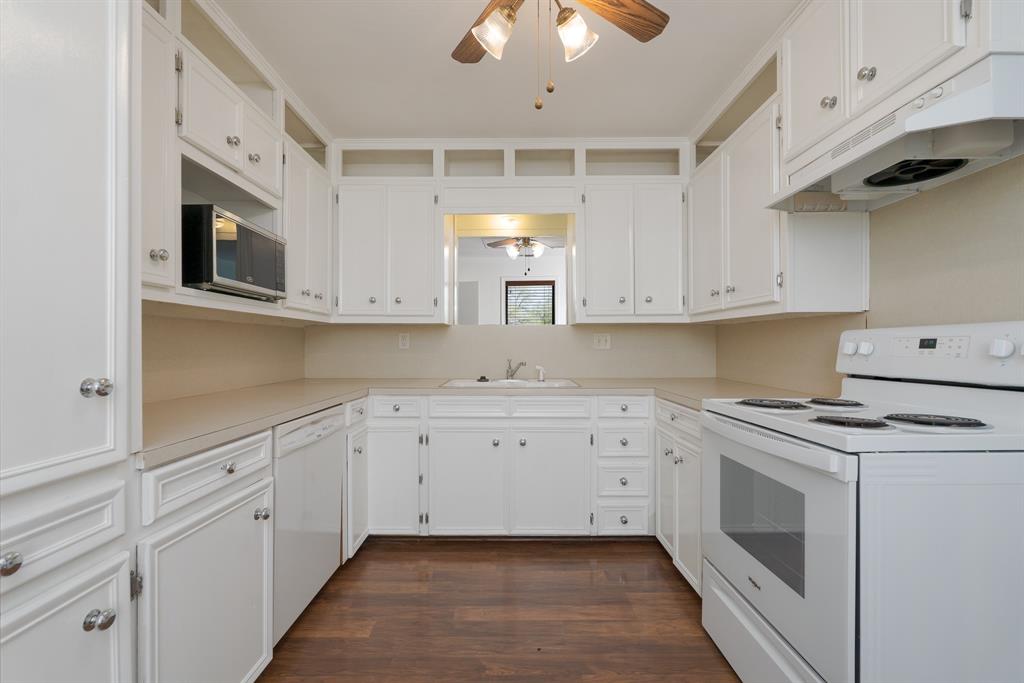 809 Turner Lane Tuscola, TX 79562 - Photo 21 of 25 Kitchen featuring white appliances, a ceiling fan, under cabinet range hood, and dark wood finished floors