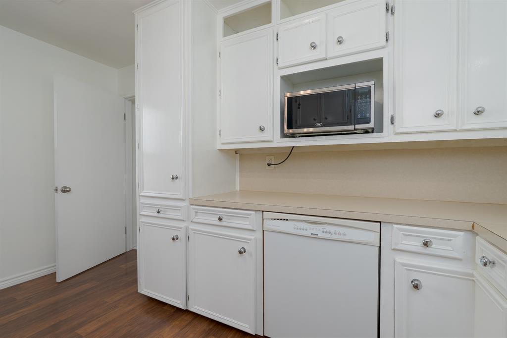 809 Turner Lane Tuscola, TX 79562 - Photo 22 of 25 Kitchen featuring dishwasher, white cabinets, light countertops, dark wood finished floors, and stainless steel microwave