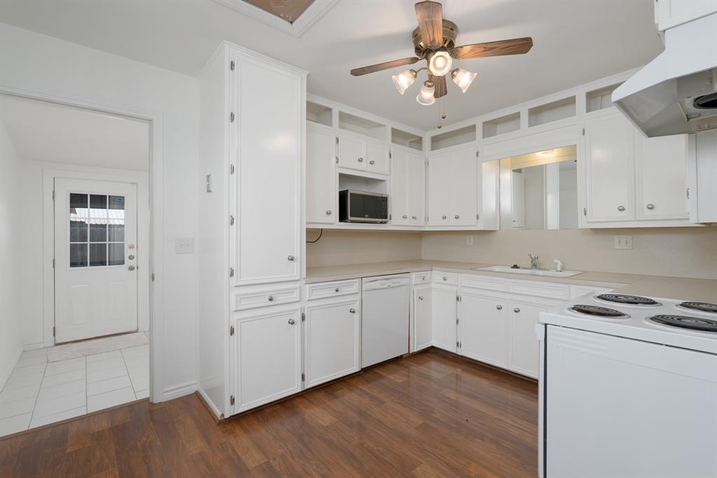 809 Turner Lane Tuscola, TX 79562 - Photo 24 of 25 Kitchen featuring white appliances, dark wood-style floors, extractor fan, a ceiling fan, and light countertops