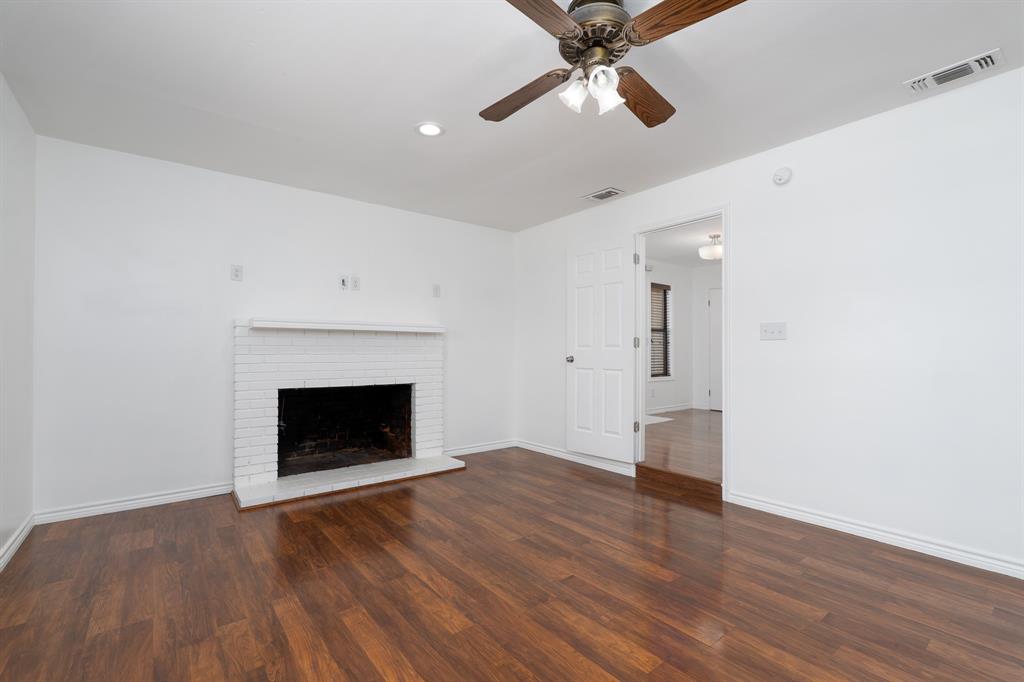 809 Turner Lane Tuscola, TX 79562 - Photo 3 of 25 Unfurnished living room with wood finished floors, a fireplace, ceiling fan, and recessed lighting