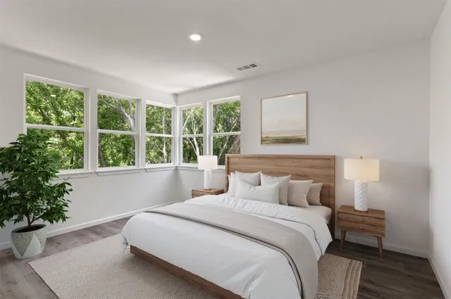 a bedroom with a large bed and a potted plant