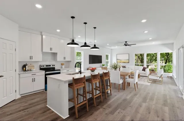 a view of a kitchen with kitchen island stainless steel appliances a dining table and chairs